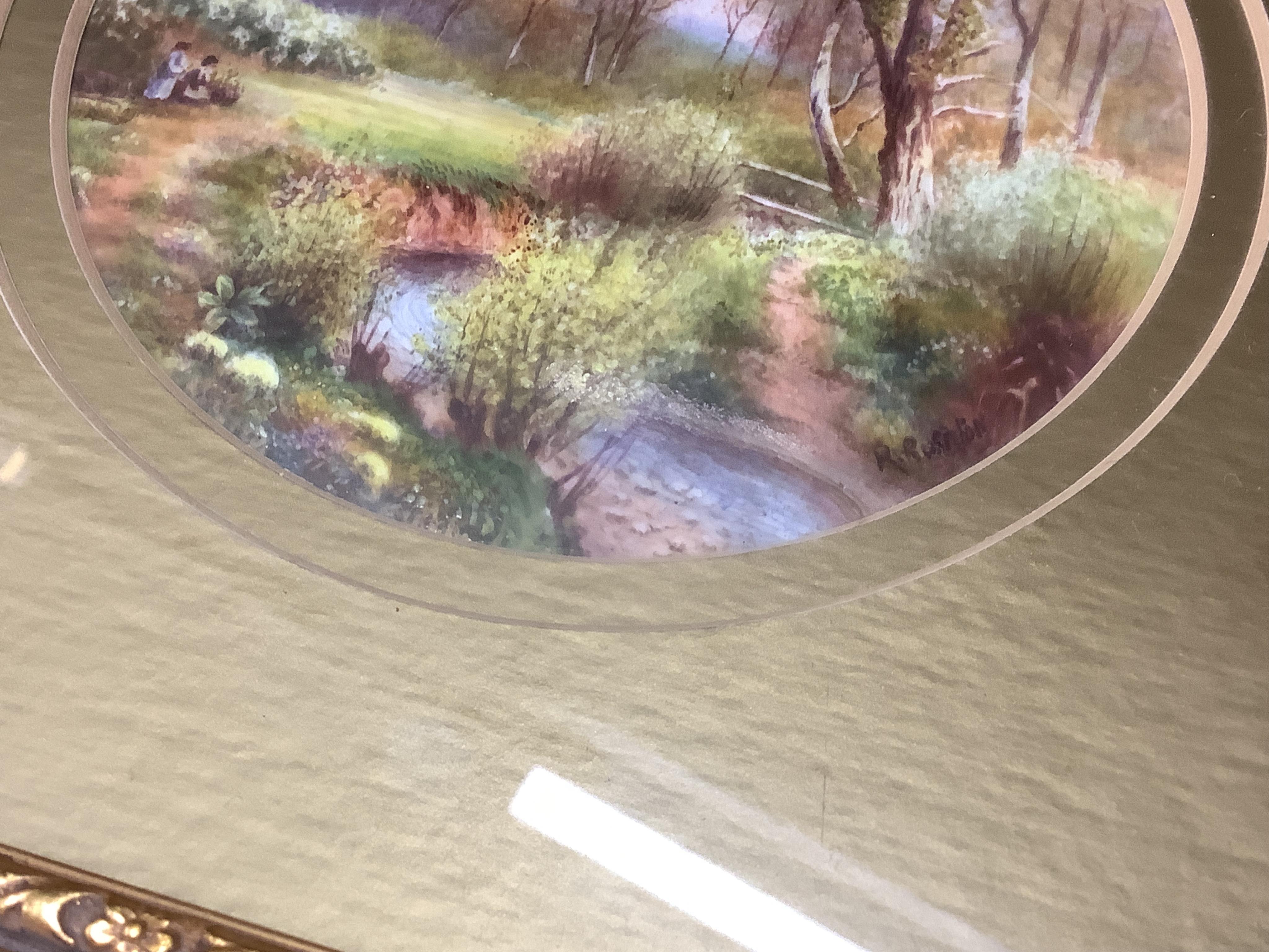 A Royal Worcester circular porcelain plaque depicting a ‘Eckley Woods’ by Raymond Rushton, gilt framed, overall 28cm high